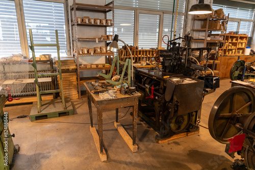 Blick in eine historische Werkstatt mit antiken Druckmaschinen und Arbeitsstationen in einer Industriehalle