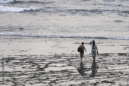 Couple Walking on Hazy Beach at Vila Nova de Milfontes, Portugal