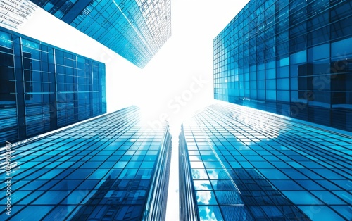 Towering blue-tinted skyscrapers stretch into a bright sky.