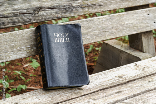 The Holy Bible resting on a park bench