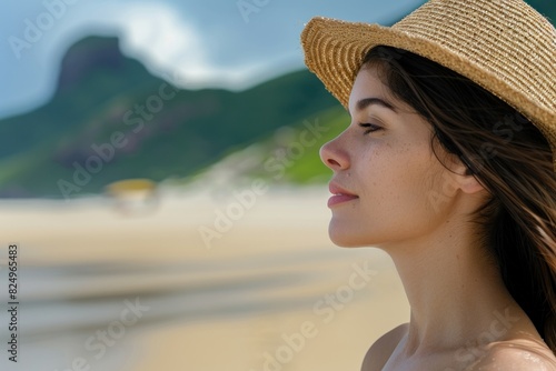 Woman in straw hat relaxing on beach with eyes closed enjoying serene sky beauty as a moment of peace and tranquility