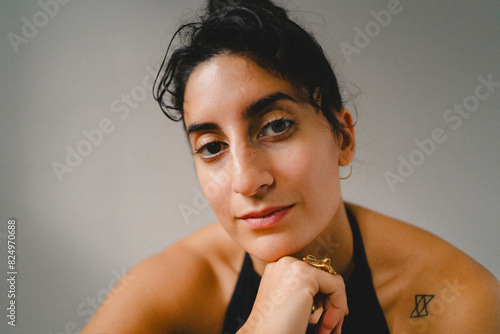 Close-up portrait of young woman against white wall