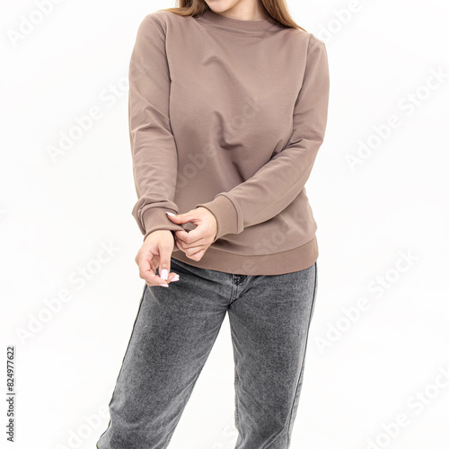Attractive woman in brown long sleeve shirt. Cotton sweatshirt and jeans on white background