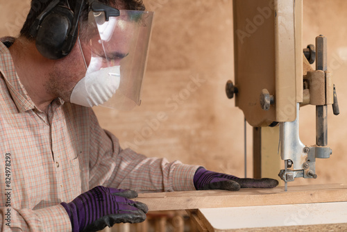 Carpentry worker using band saw in a woodworking workshop