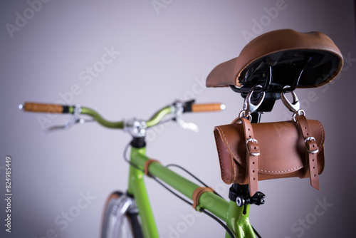 green bicycle isolated on light grey studio backdrop  leather bike saddle  green frame