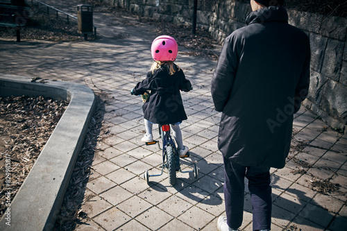 Rear view of mother and daughter spending leisure time in park photo