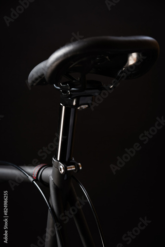 black bike saddle and frame on dark studio backdrop