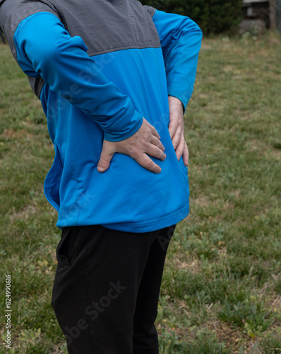 Back pain in an adult man on the grass © Jonatan