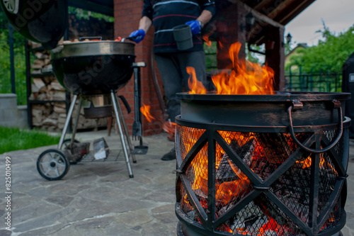 The male hand and warm fireplace with lots of trees ready for barbecue