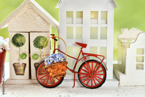 Home decor with red metal bike standing in front of miniature houses