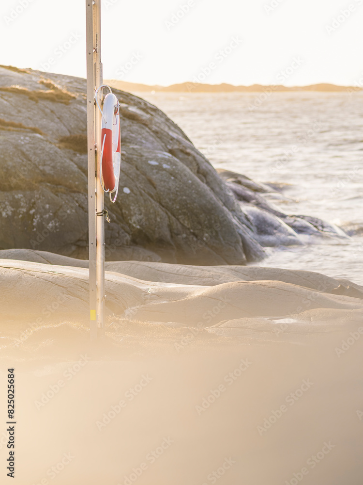 Inflatable life buoy on pole at beach during sunset Inflatable life buoy on pole at beach during sunset