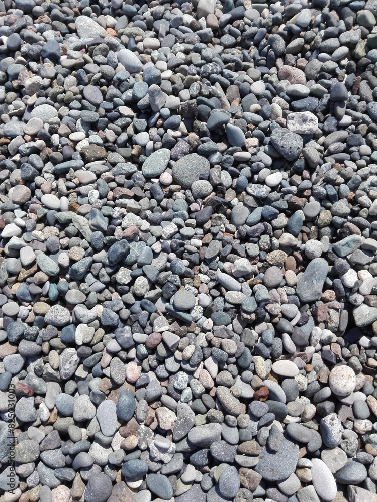 Big red stone and sea pebbles as frame on beach. Multicolor stone pebbles as natural abstract texture background with space for text. Close up colorful Pebble stone on coast. Filled full stone frame. Big red stone and sea pebbles as frame on beach. Multicolor stone pebbles as natural abstract texture background with space for text. Close up colorful Pebble stone on coast. Filled full stone frame.