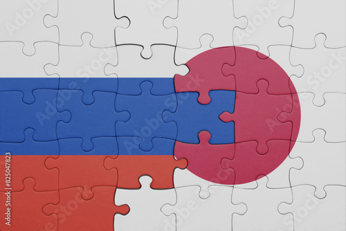 puzzle with the colourful national flag of japan and flag of russia.