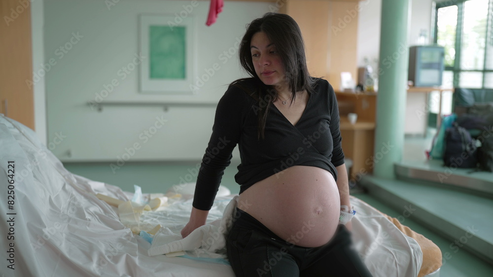 Pre Labour Expecting mother leaning at hospital bed during pre labor contractions ...