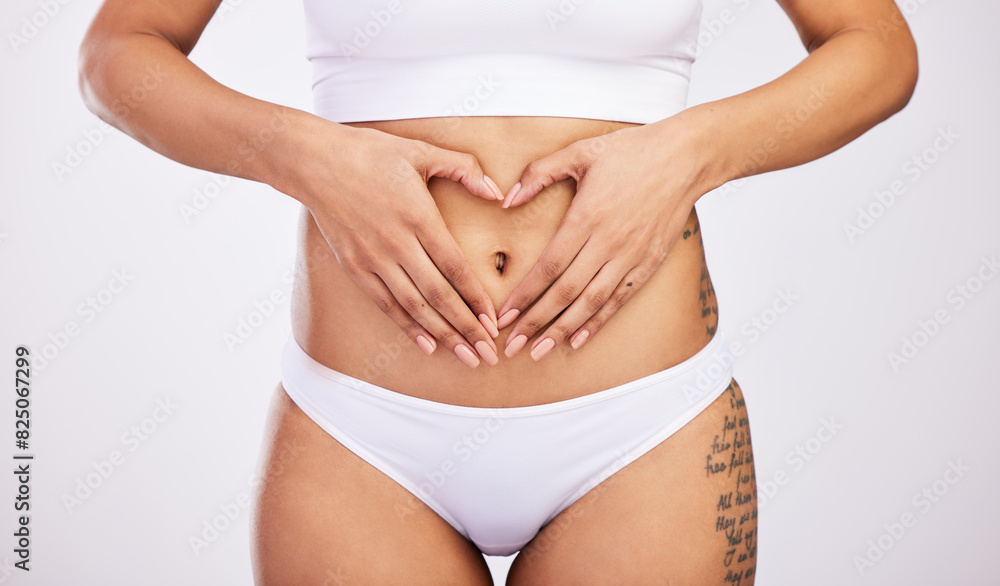 Woman, heart and hands on stomach in studio, diet and weight loss for gut health. Fitness, body wellbeing and abdomen of girl for wellness or digestion, balance and nutrition in white background