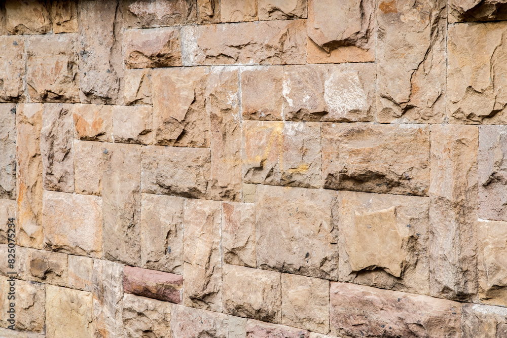 Solid house stone wall of roughly hewn stone closeup as stone background Solid house stone wall of roughly hewn stone closeup as stone background