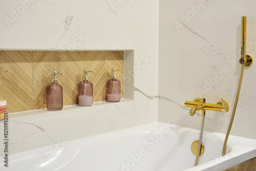 Jasna łazienka z marmurowymi płytkami i złotym kranem