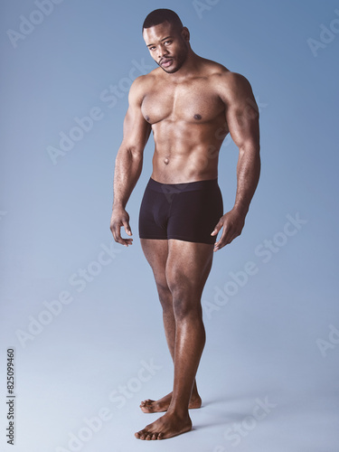 Black man  portrait and serious for fitness in studio  wellness and strong on blue background. Male person  athlete and proud bodybuilder for training  exercise and shirtless for workout challenge