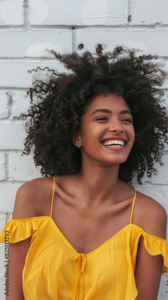 A woman with curly hair is smiling and wearing a yellow top A woman with curly hair is smiling and wearing a yellow top