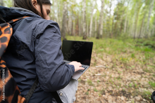 person with laptop in forest