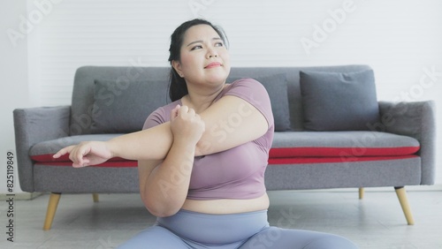 Fat Asian woman stretches her arms to warm up before exercising.