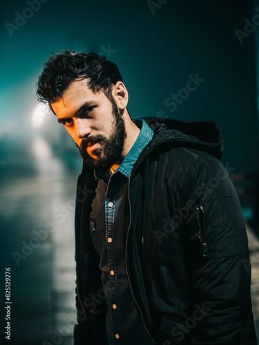 Man Standing On Foggy Street At Night With Streetlights Illuminating