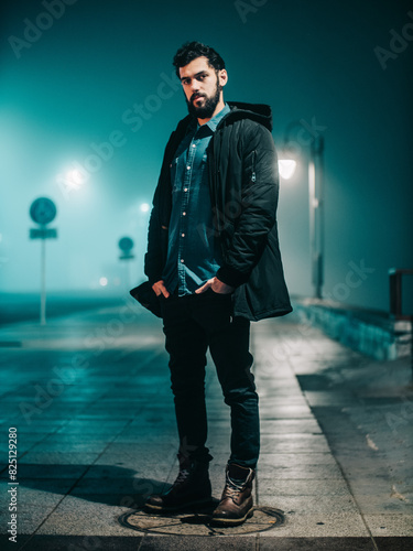 Man Standing On Foggy Street At Night With Streetlights Illuminating
