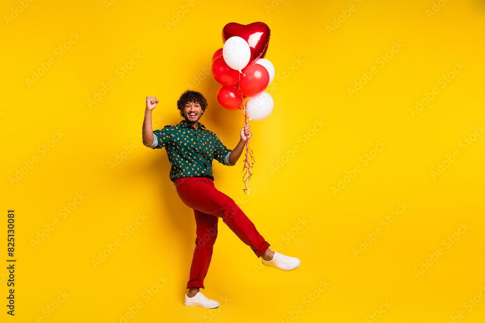 Photo of cheerful elegant man wear stylish clothes hold balloons celebrate event isolated on yellow color background Photo of cheerful elegant man wear stylish clothes hold balloons celebrate event isolated on yellow color background