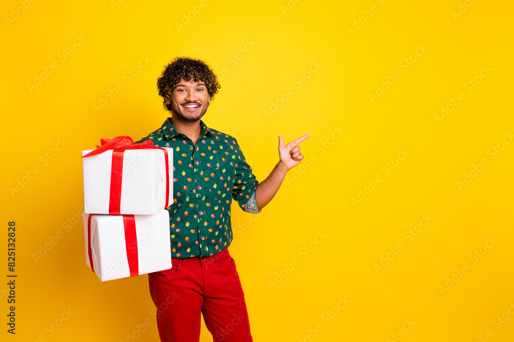 Photo of attractive elegant young man giftbox direct finger empty space wear shirt isolated on yellow color background Photo of attractive elegant young man giftbox direct finger empty space wear shirt isolated on yellow color background