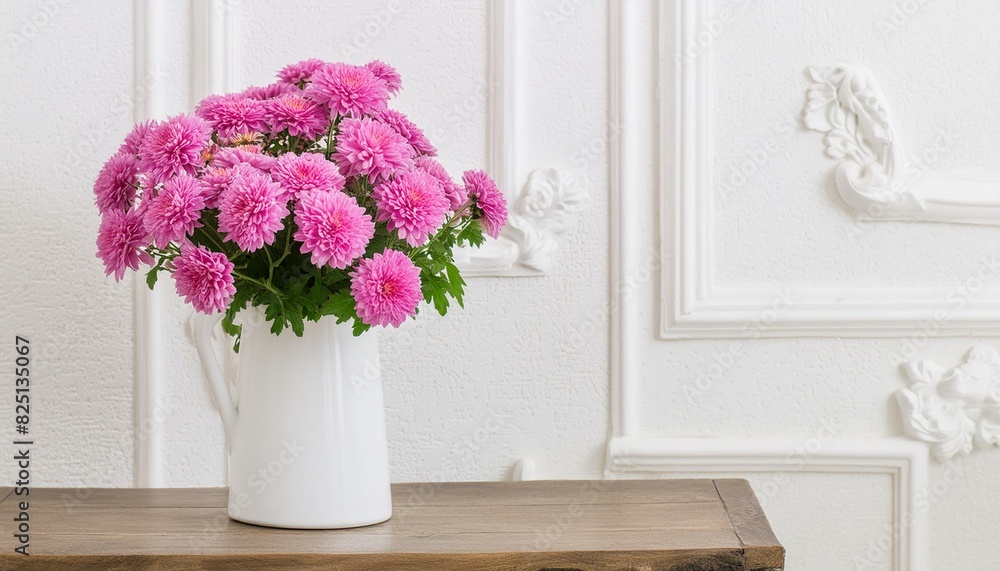 Pink chrysanthemums in white vase on white interior