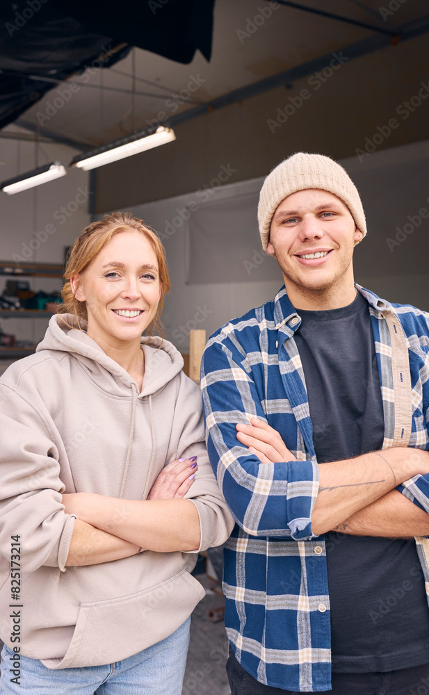 Portrait Of Smiling Male And Female Workers Standing In Doorway Of Concrete Workshop Portrait Of Smiling Male And Female Workers Standing In Doorway Of Concrete Workshop