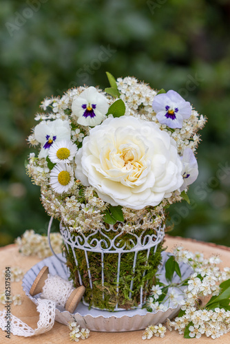 Blumen-Arrangement mit weißer englischer Rose Tranquility, Hornveilchen, Bellis und Feuerdorn-Blüten photo
