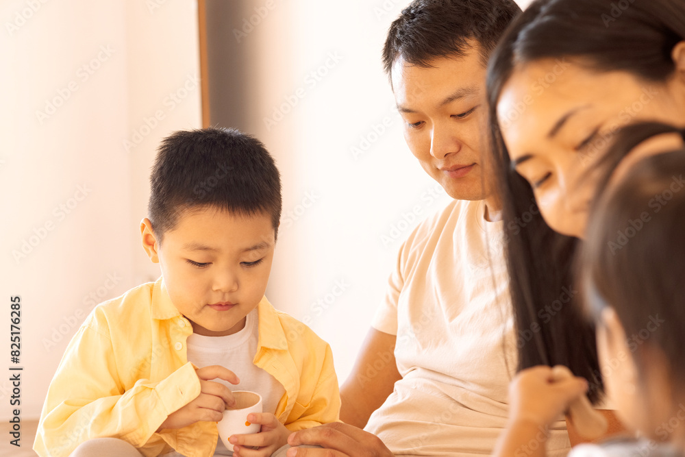 A happy Asian family. Korean parents and their cute little children play with toys at home A happy Asian family. Korean parents and their cute little children play with toys at home