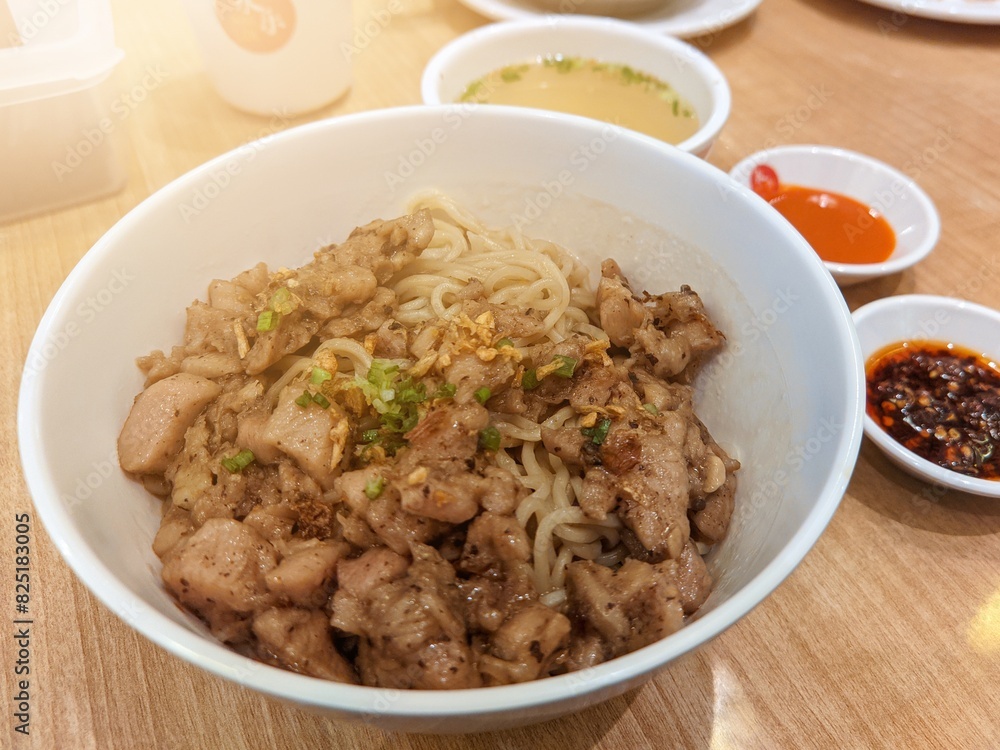 Tao Si Chicken Noodles served in a plate on a wooden table with a view of Hong Kong fast food Tao Si Chicken Noodles served in a plate on a wooden table with a view of Hong Kong fast food