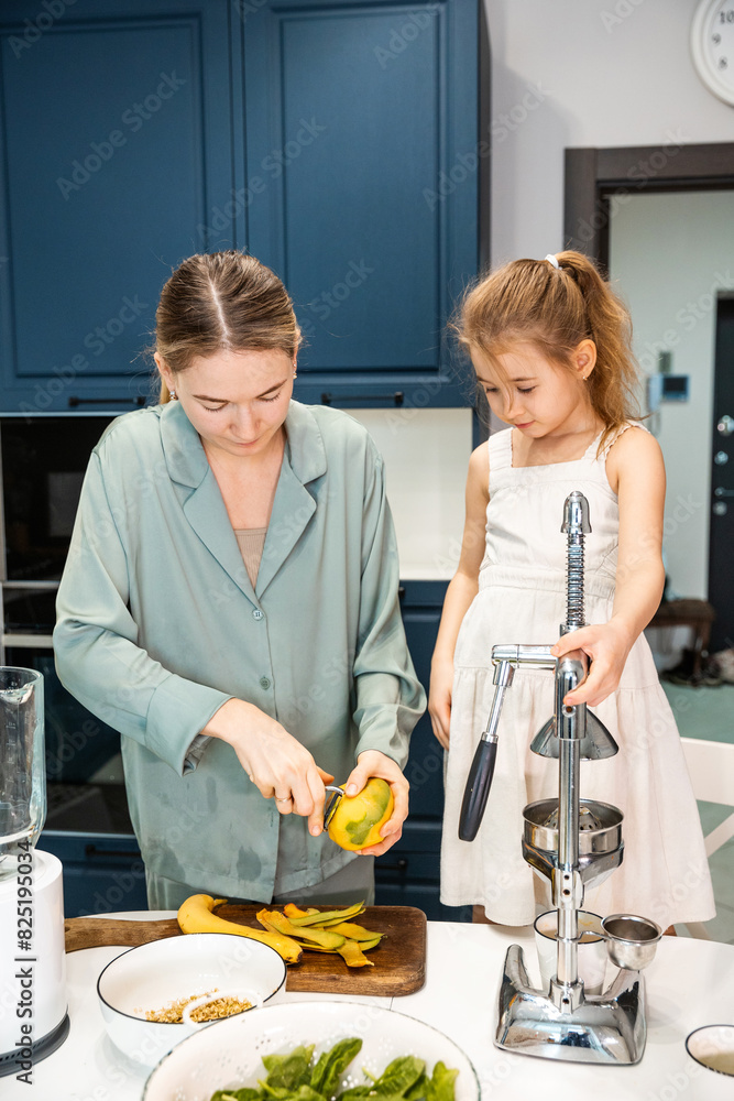 A woman and her daughter are peeling mangoes A woman and her daughter are peeling mangoes