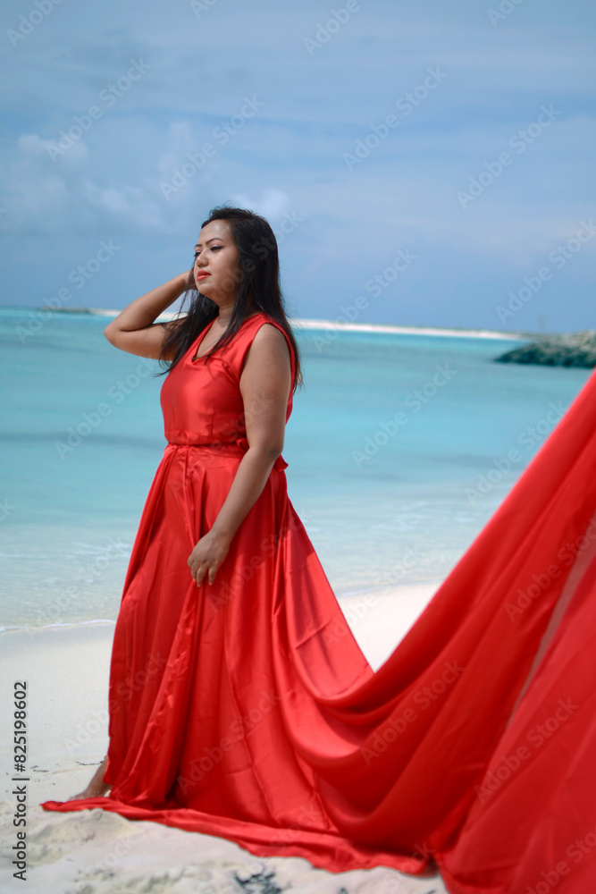 Lady in red satin flying dress flowing at the beach Lady in red satin flying dress flowing at the beach