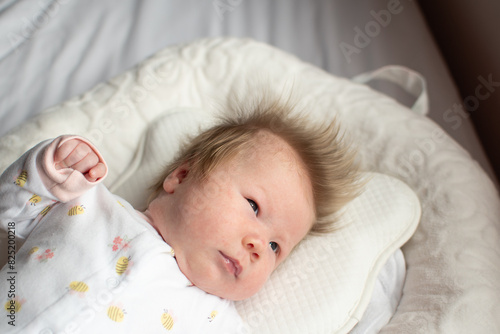 Portrait of a 1-month-old newborn baby girl. Caucasian baby in a baby nest