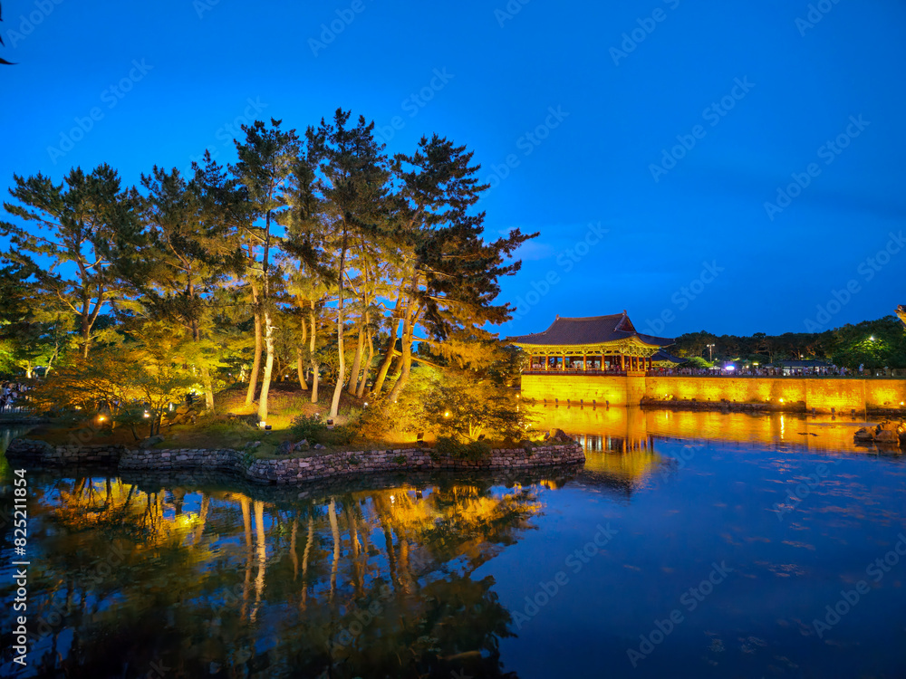 A beautiful lake with a bridge in the background. The bridge is lit up at night, creating a warm and inviting atmosphere. The water is calm and reflects the lights from the bridge A beautiful lake with a bridge in the background. The bridge is lit up at night, creating a warm and inviting atmosphere. The water is calm and reflects the lights from the bridge