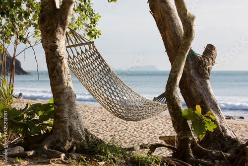 A string hammock strung between two trees photo