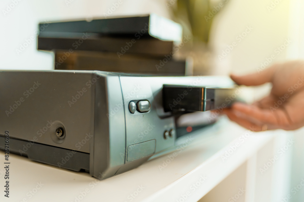 Close up of a hand holding a videotape. Retro vhs cassete in a player. Close up of a hand holding a videotape. Retro vhs cassete in a player.