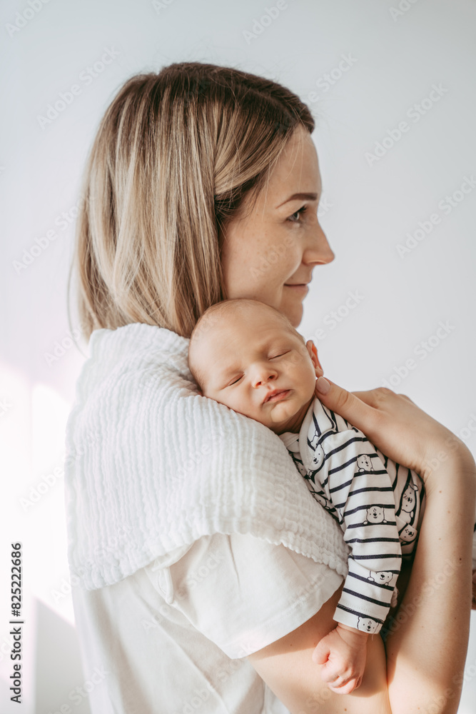 Proud and loving mother holding her sleeping baby on her chest.