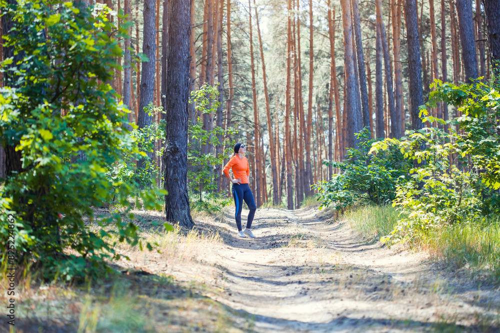 Obraz premium young girl on a morning run in a sunny pine forest