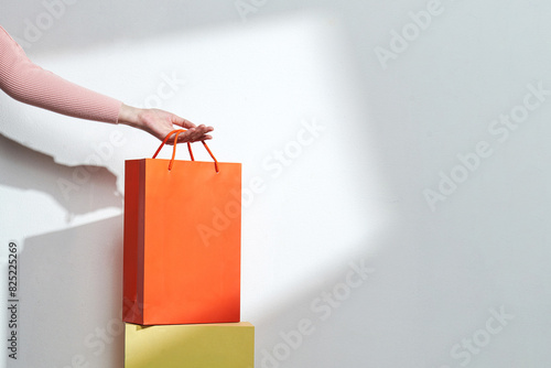 Hand-putting a bunch of shopping bags on colorful goods packaging photo