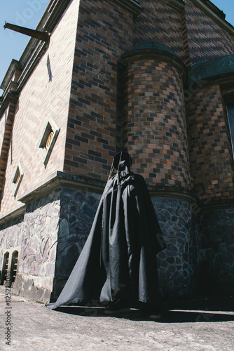 Shadow people, a person with black costume next to and old church photo