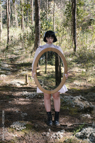 Woman holding a mirorr reflecting a forest  photo