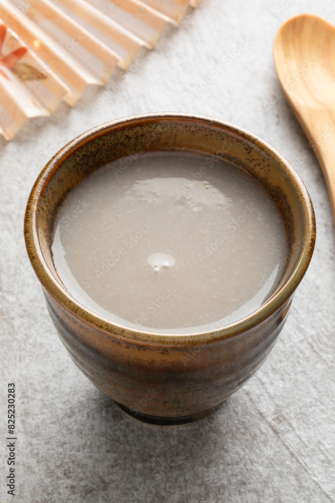 Single cup of Japanese kuro Amazake, fermented rice drink close up Single cup of Japanese kuro Amazake, fermented rice drink close up
