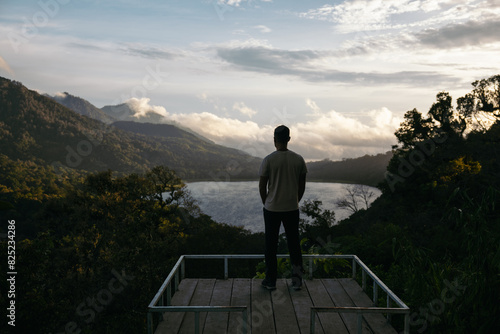 Man at a viewpoint of a landscape with a lake in the mountains photo
