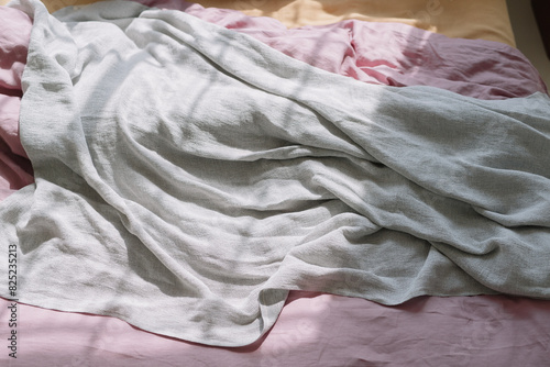 Crumpled white linen on a pink bed photo