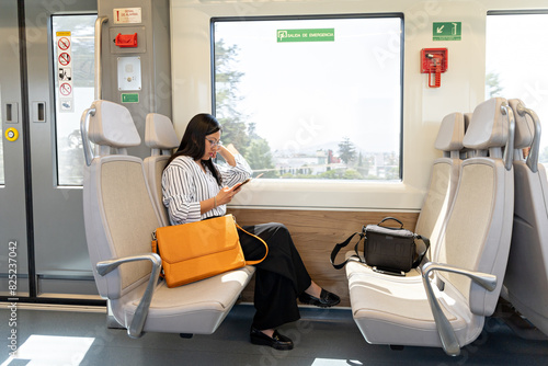 While commuting home from work, a woman engages with her smartphone photo
