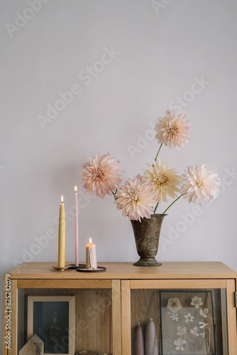 Dahlia arrangement with candles on a cabinet photo